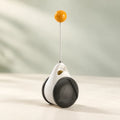 PawPivot black-and-white balance toy with a slender stem and yellow top ball.
