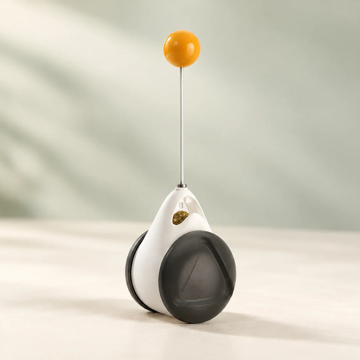 PawPivot black-and-white balance toy with a slender stem and yellow top ball.