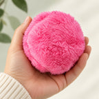 RoamRoll pink cloth-covered ball held in an adult hand for scale.