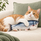 Ginger-and-white cat holding a FinFlip Blue Fish plush toy.